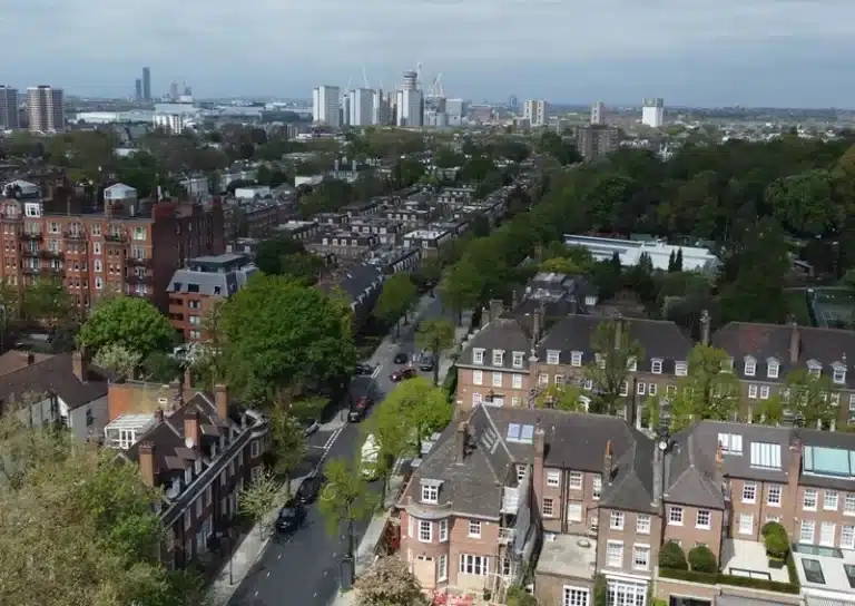 Aerial view of residential buildings and tree-lined streets in London, showcasing urban landscape for drone roof survey services by Environ Restoration Services.