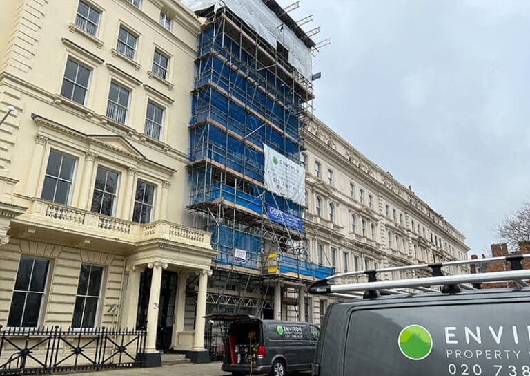 Georgian house restoration project in London with scaffolding, showcasing Environ Restoration Services branding and ongoing restoration work.