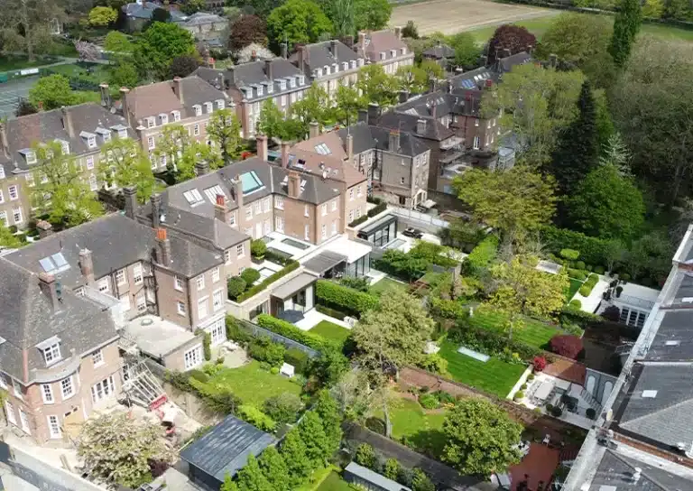 Aerial view of residential buildings with well-maintained gardens in London, showcasing the detailed landscape and roof structures relevant to drone survey inspections.