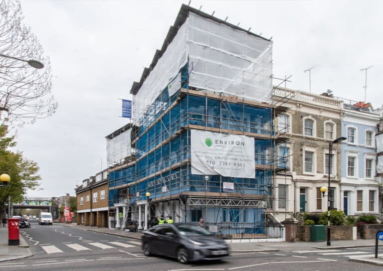 Georgian house under renovation with scaffolding and protective sheeting, featuring Environ Restoration Services branding, showcasing expertise in historic property restoration in London.