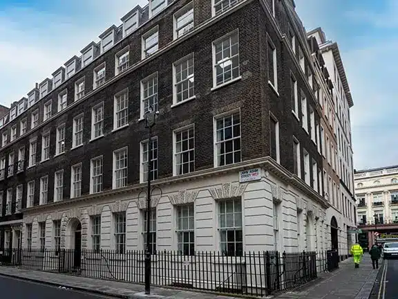 Historic listed building exterior in London, showcasing restored brick and white façade, highlighting architectural details and traditional craftsmanship.