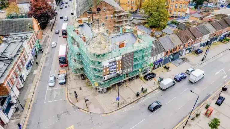 Restoration project of a historic building in London, surrounded by scaffolding and construction materials, showcasing the combination of modern techniques and traditional architecture.