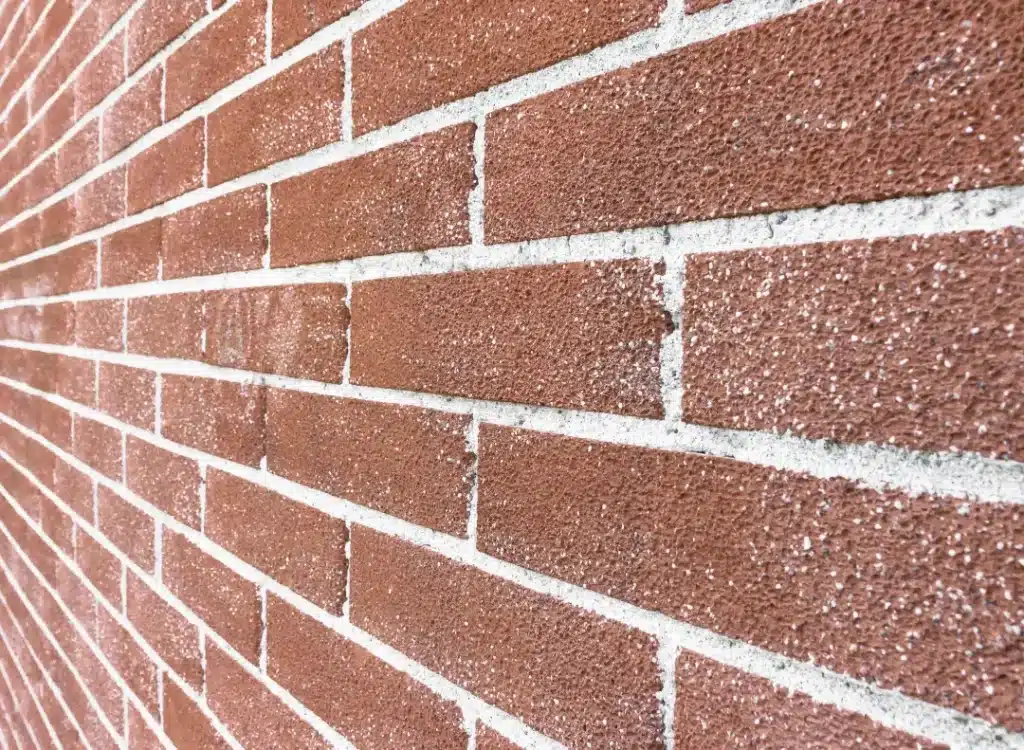 Brick wall with visible mortar joints, showcasing texture and potential for damage from improper pressure washing techniques, relevant to brick cleaning and restoration services.