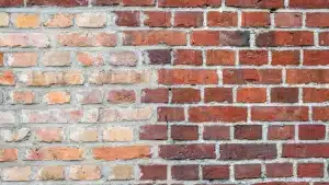 Brick wall showing contrasting sections of clean and dirty bricks, illustrating the importance of regular brick cleaning for maintenance and restoration.