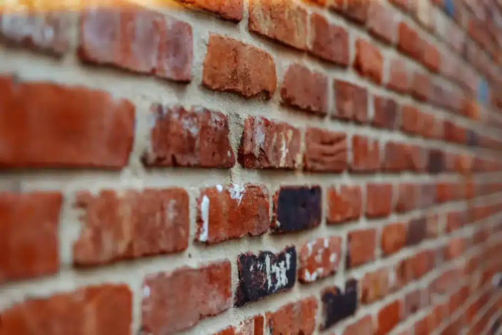 Close-up of a brick wall showing various textures, colours, and signs of wear, relevant to brick cleaning and restoration services in London.